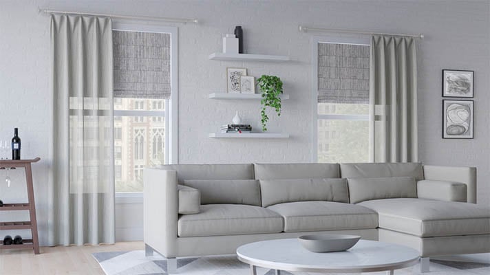 Drapery layered over roman shades