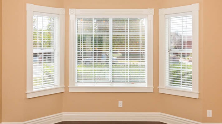 White faux wood blinds in a bay window